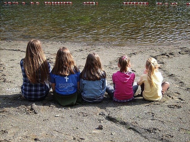 Children sitting looking out at a lake