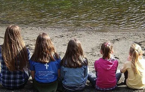 Children sitting looking out at a lake