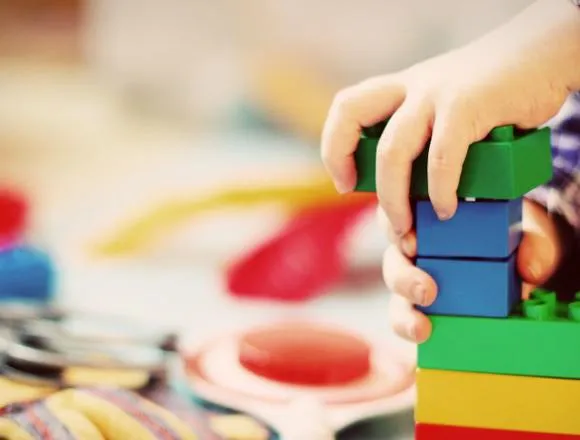 A child's hands playing with building blocks