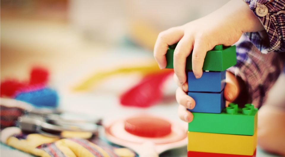 A child's hands playing with building blocks