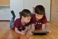 Two children using a digital device