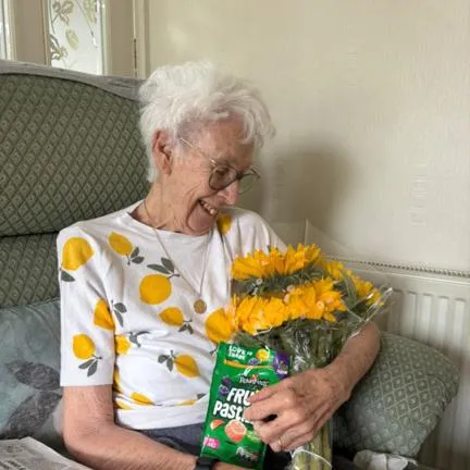 Care user with flower that our care worker gifted.