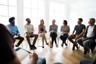 Group of eight people sitting and talking
