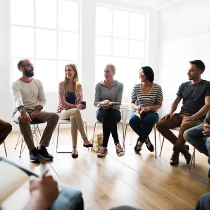 Group of people sitting in a circle on chairs
