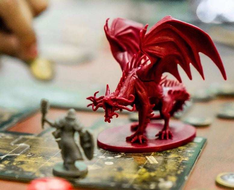 Board game plastic figurines of dragon and person with mace & shield