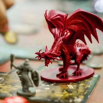 Board game plastic figurines of dragon and person with mace & shield