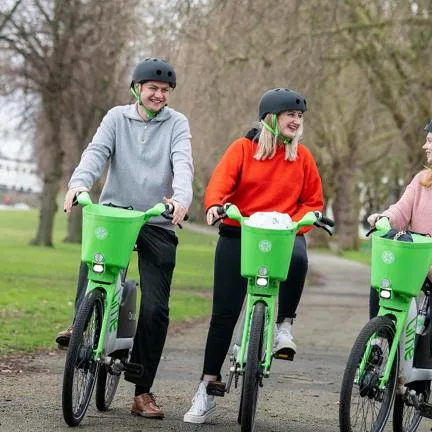 Three people using bright green e-bikes