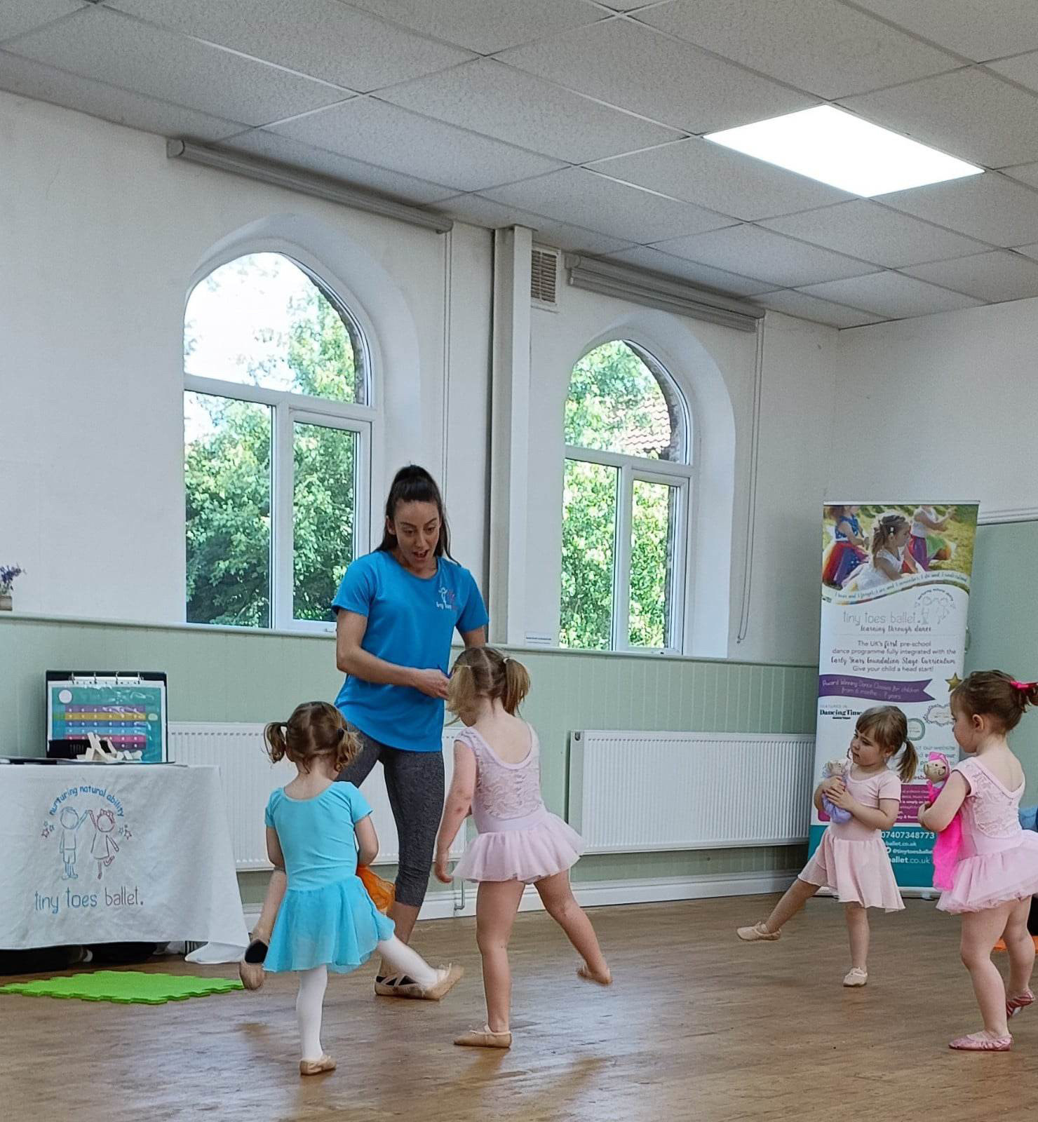 photograph from a ballet session, the leader and the children doing ballet