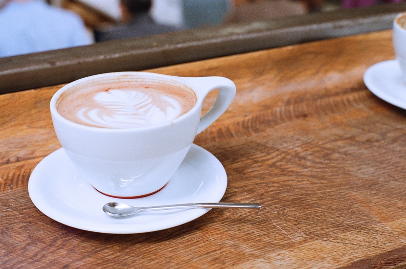 Coffee cup with Saucer and spoon on a wooden table.