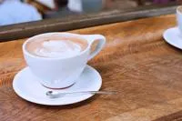 Coffee cup with Saucer and spoon on a wooden table.