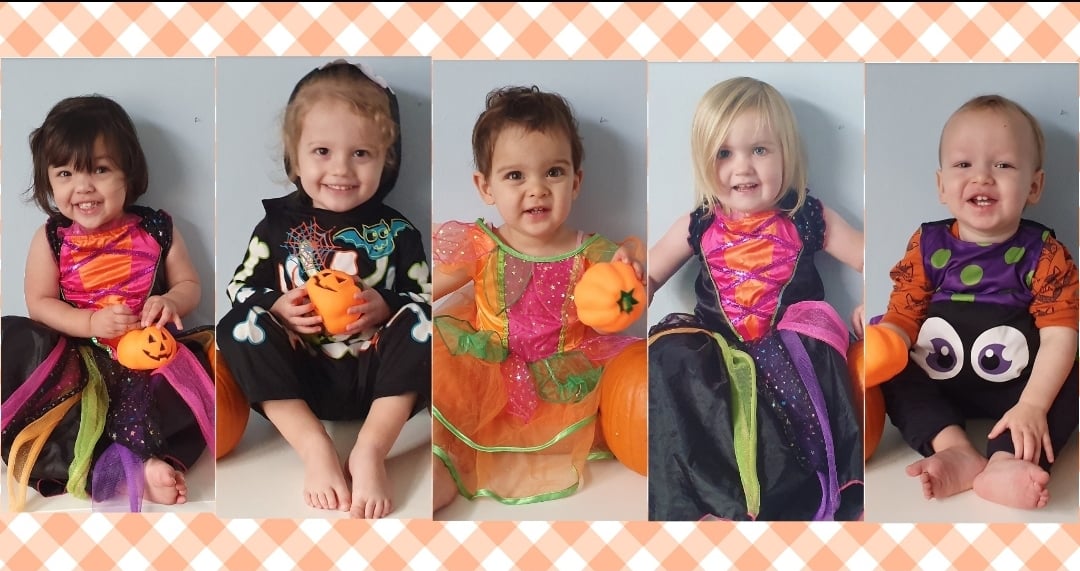 A row of five preschool children in Halloween costumes
