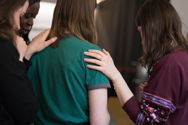 People with hands on each others shoulders