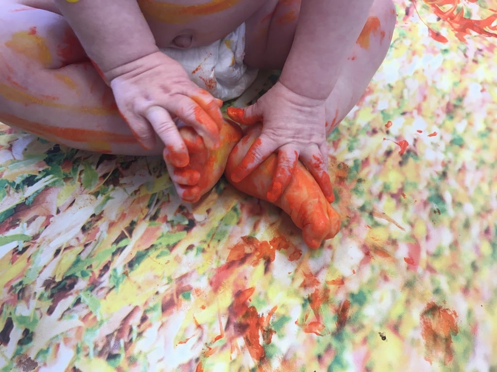 Baby feet covered in orange paint
