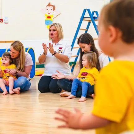 Parents and children sat in a circle singing and clapping